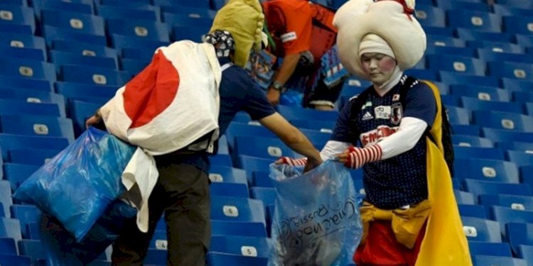 Suporter Jepang memunguti sampah usai pertandingan pembukaan Piala Dunia 2022/Net